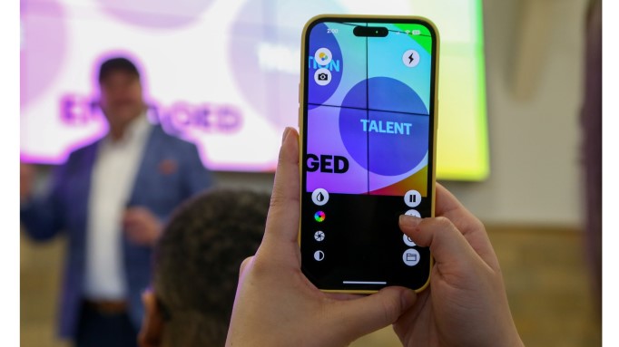 person watching a presentation and holding an iPhone running ReBokeh
